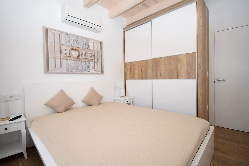 1 Schlafzimmer mit Doppelbett, Klima, Einbauschrank, SAT-TV und Fenster zur hinteren Terrasse (mit Fliegengitter u. elek