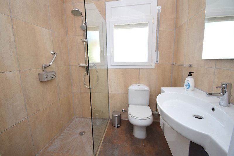 Badezimmer mit ebenerdiger Dusche, Waschbecken, WC u. Fenster