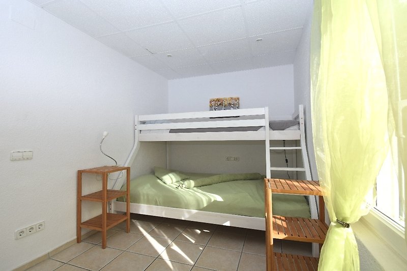 Gemütliches Schlafzimmer mit Holzbett, Etagenbett und Einbauschrank