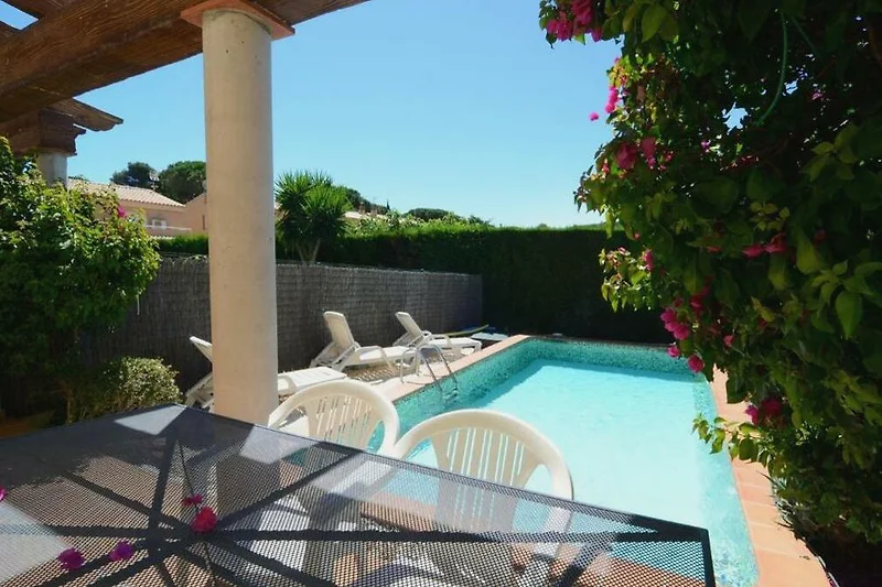 Terrasse, Pool und stilvolle Outdoor-Möbel im grünen Resort-Garten.