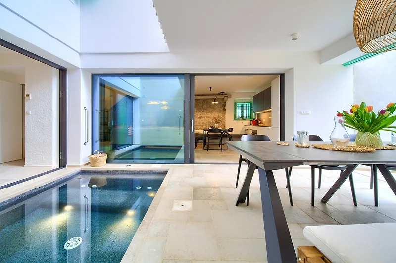 Einladende Sitzecke mit Holzdetails, Glastür und geschmackvollem Licht.