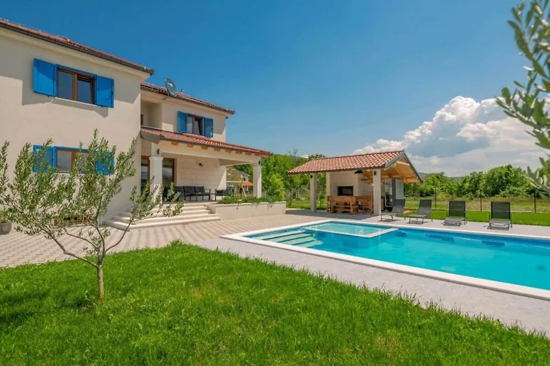 Großer Pool im grünen Garten einer exklusiven Villa zur Erholung.