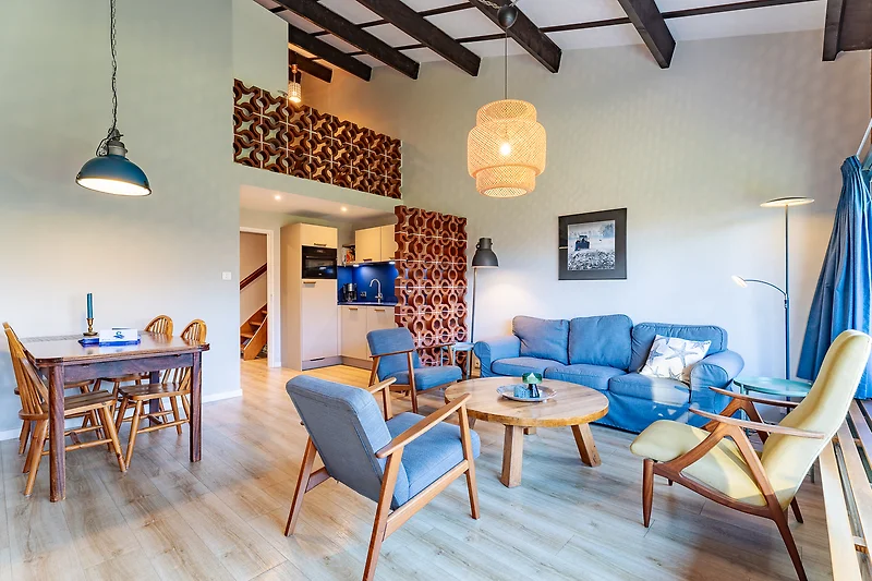 Großzügiger Wohnbereich mit Sofa, Esstisch, Pflanzen und Designerlampe.