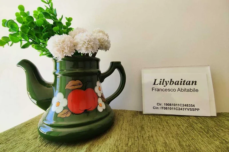 Keramikgeschirr, Kanne und frische Rosen sorgen für einladende Akzente.