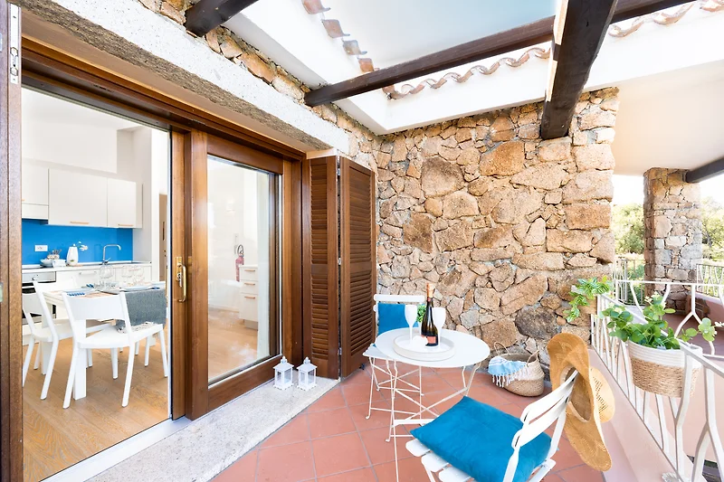 Penthouse mit Balkon, Pool, Outdoor-Möbeln und blühenden Pflanzen.