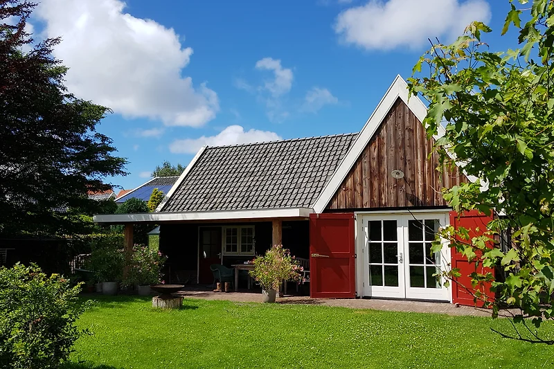 Großer Garten mit Bauernhaus, Nebengebäuden und schattigem Rasen.