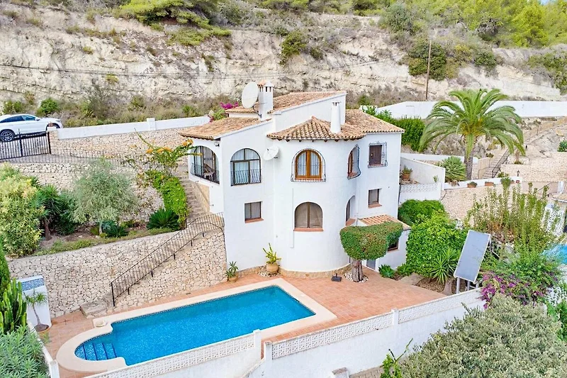 Villa mit Pool, Palmen und gepflegtem Garten im Ferienort.