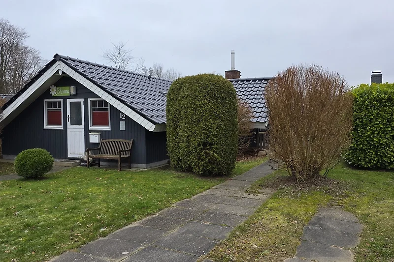 Freistehendes Haus mit gepflegtem Vorgarten und Parkplatz.