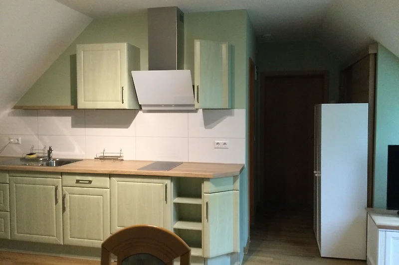 Hochwertige Holzmöbel und voll ausgestattete Küche mit Gasherd.