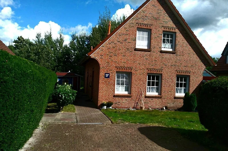 Ostfriesisches Backsteinhaus mit gepflegtem Garten und eigener Einfahrt.