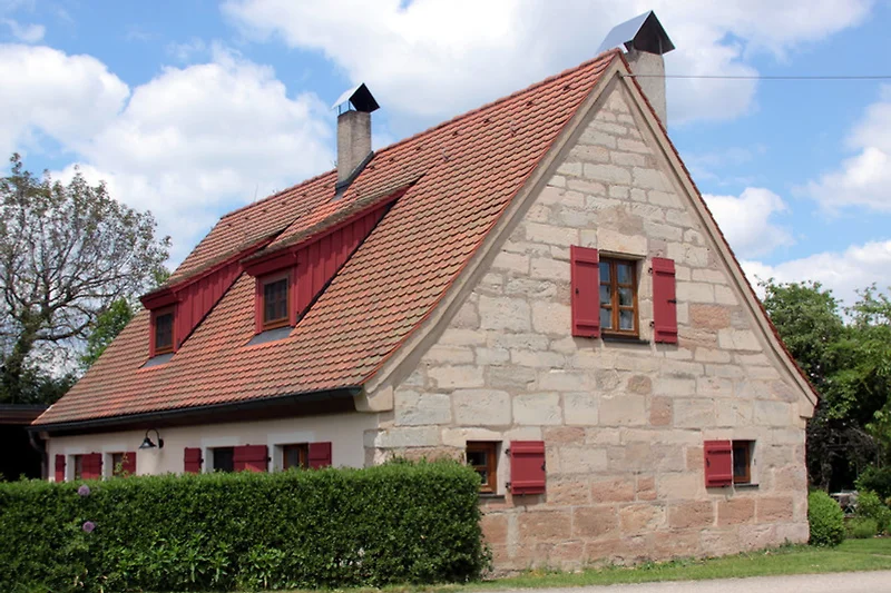Ferienhaus mit markantem fränkischen  Dach, Kachelofen und PKW-Stellplatz.
