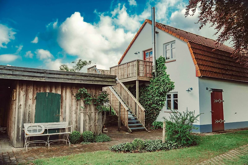 Landhaus mit gepflegtem Garten, großzügigem Hof und sichtbarem Zaun.