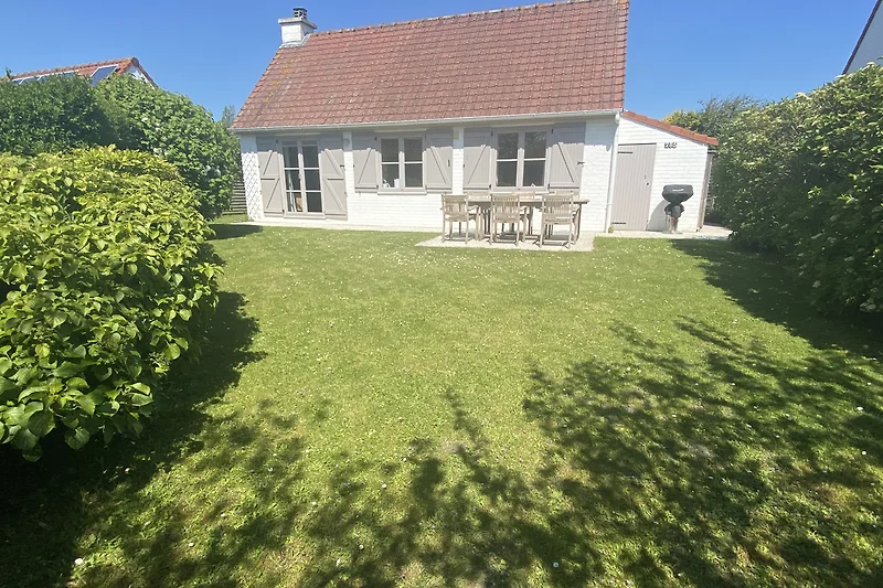 Villa mit weitläufigem Rasen, gepflegtem Garten und einladender Zufahrt.