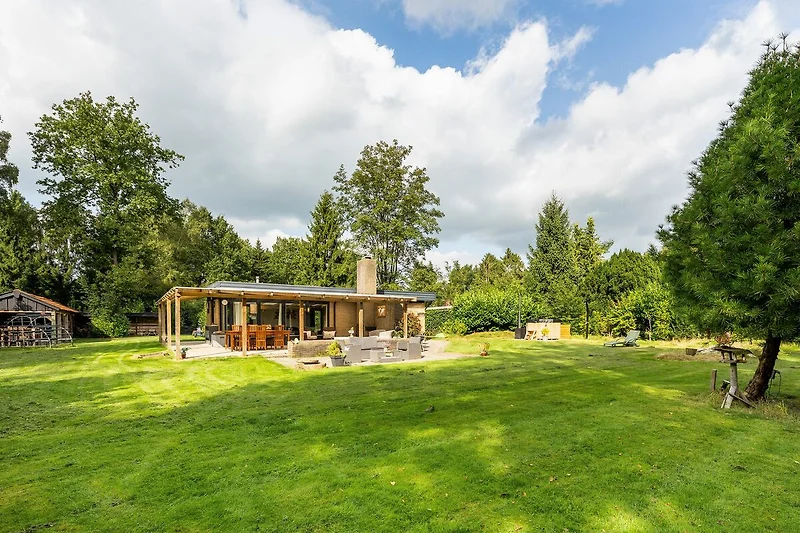 Großes Gartengrundstück mit Bäumen, Wiese und rustikalem Holzhaus.