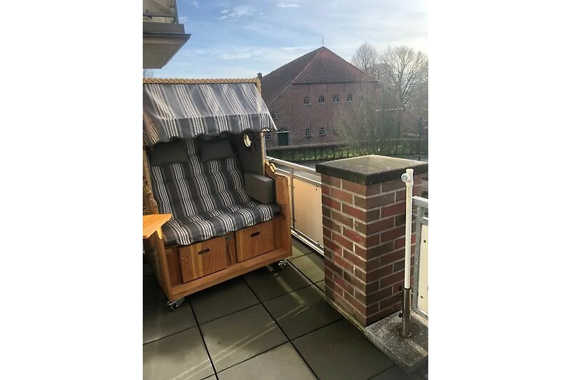 Sonniger Balkon mit hochwertigem Strandkorb und separatem Essplatz direkt am Dorfplatz.
