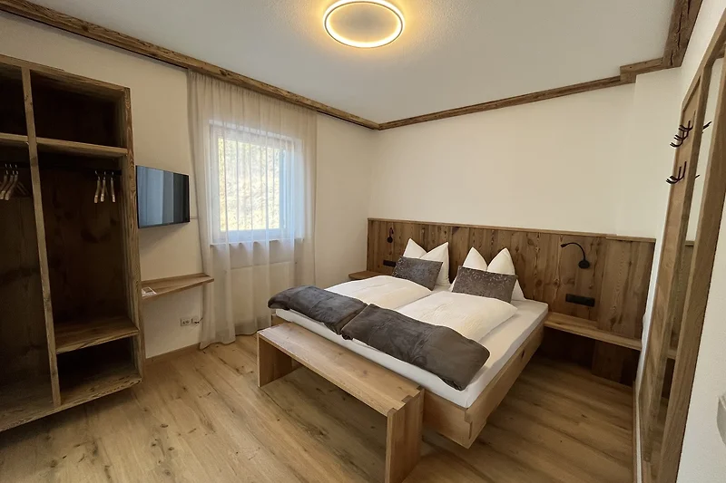 Rustikale Blockhütte mit sichtbaren Balken und stabilem Holzrahmenbett.