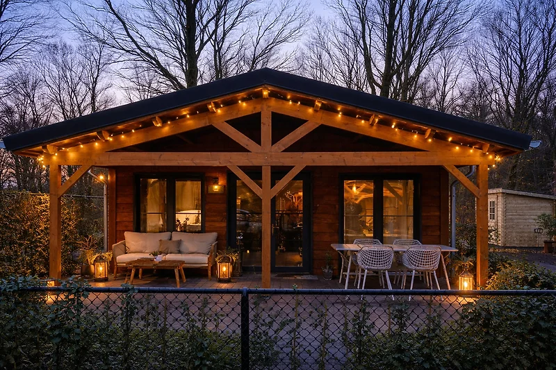 Blockhaus mit Holzveranda, Gartenpavillon und überdachter Terrasse.