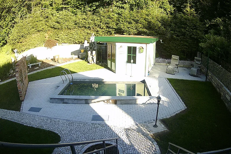 Cottage mit Pool, gepflegtem Rasen, Garten und künstlichem Grün.