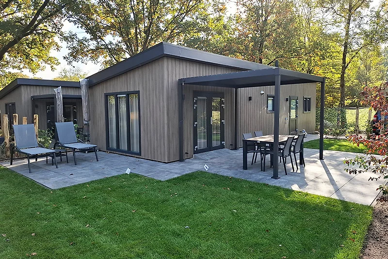 Großer Garten mit Hof, Terrasse, Nebengebäuden und Bauernhaus.