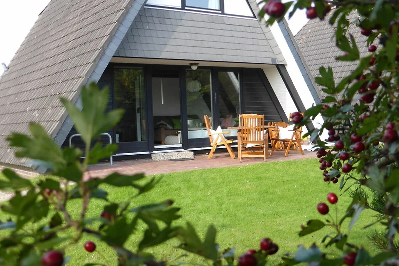 Großzügiger Garten, markantes Satteldach und gepflegte Einfahrt.