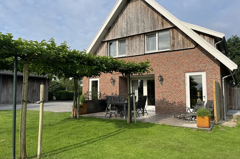 Historisches Backsteinhaus mit großem Garten und einladender Einfahrt.