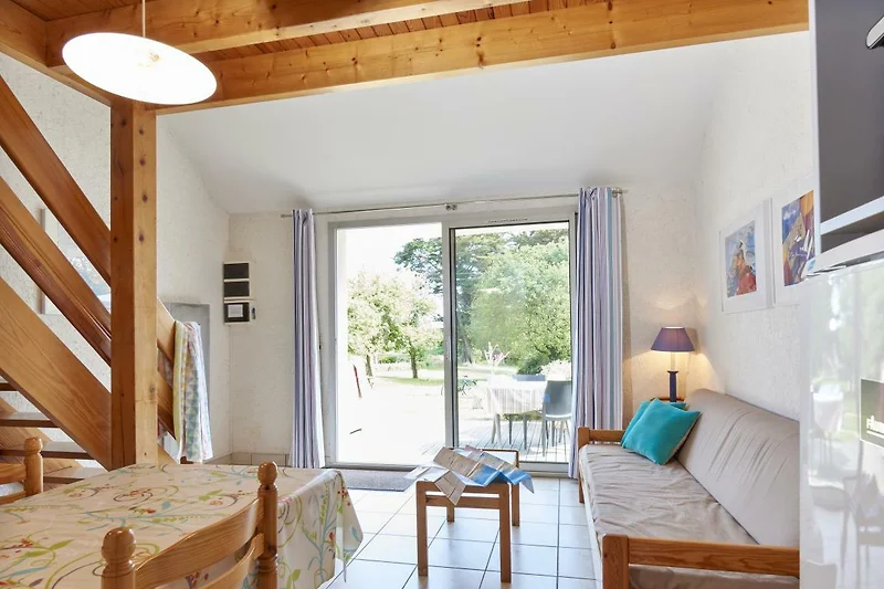 Hochwertige Holzmöbel, Esstisch und Pflanzen auf sonniger Terrasse.