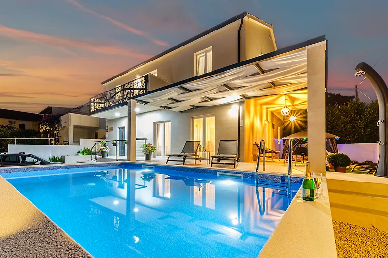 Beleuchteter Pool im Eco-Resort mit Therme und Blick auf die Anlage.