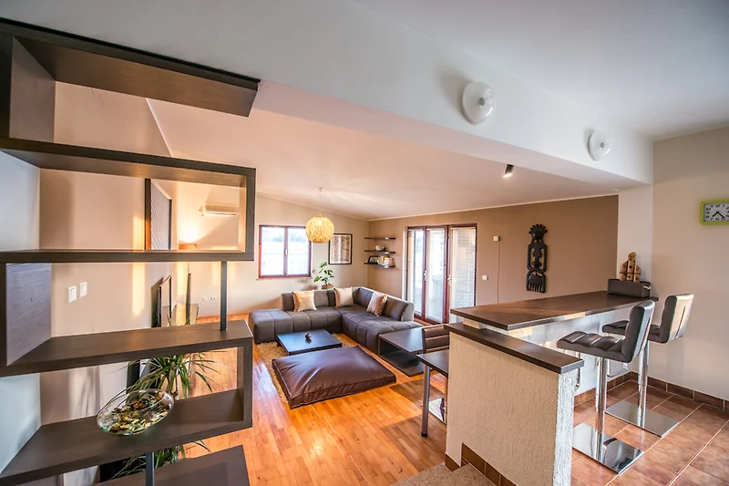 Großzügiger Wohnbereich mit Sofa, Esstisch, TV und stilvollem Licht.