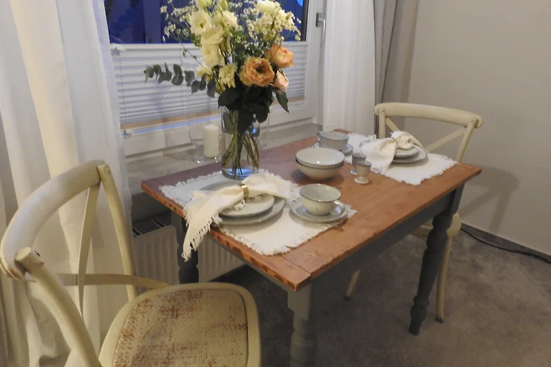 Charmanter Essbereich mit Holztisch, frischen Blumen – hier fehlen nur noch Sie