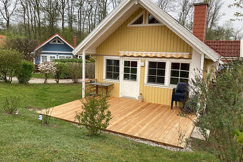 Großzügige Veranda, Holzfassade und Gartenhaus im grünen Hinterhof.