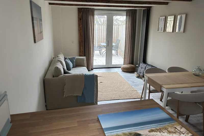 Sofa mit Kissen, Couchtisch, Lampe und dekorativem Bilderrahmen.