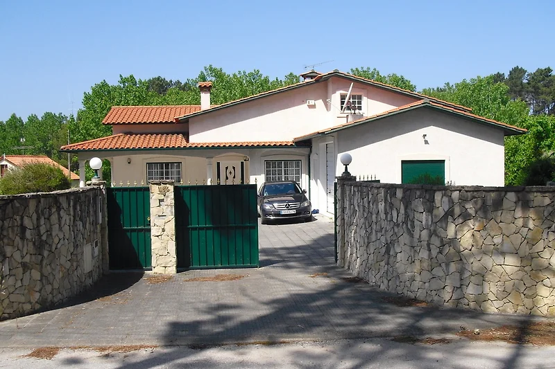 Einfahrt mit Tor, gepflegtes Anwesen und Haus im ruhigen Wohngebiet.