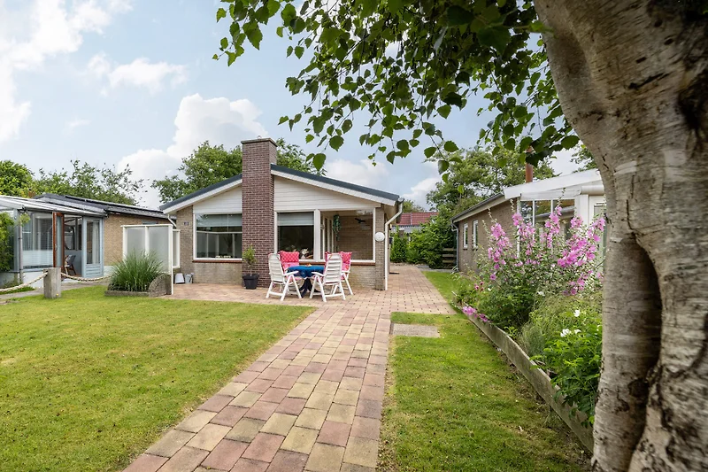 Großes Haus mit Garten und windgeschuetzter Terrasse.