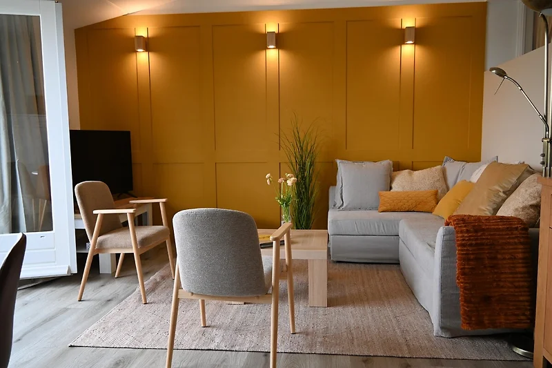 Luxuriös Wohnzimmer mit Holzmöbeln, Komfortabele (schlaf)Sofa, Esstisch und Zimmerpflanzen.