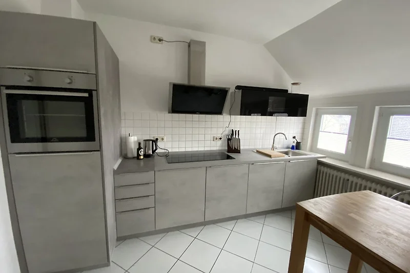 Voll ausgestattete Küche mit Gasherd, Spüle und großzügiger Arbeitsfläche.