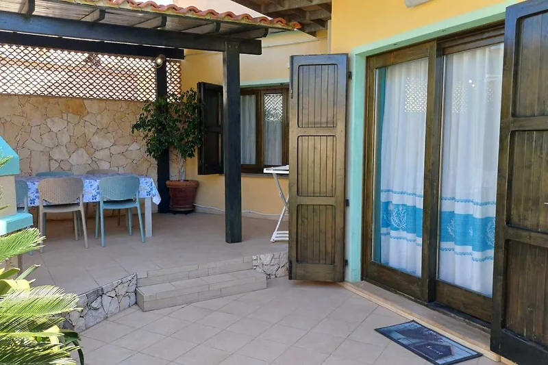 Holzmöbel, Pflanzen und Balkon mit Outdoor-Lounge für entspannte Stunden.