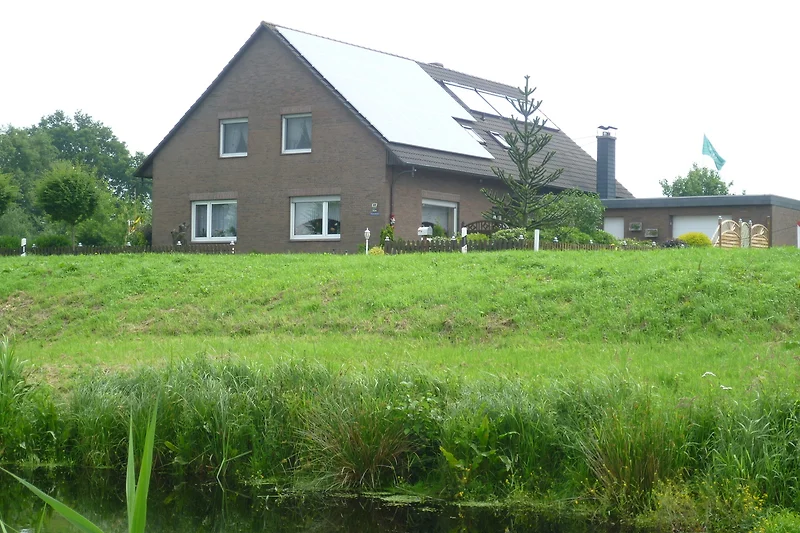 Gemütliches Landhaus mit großem Garten und Blick auf grüne Wiesen.
