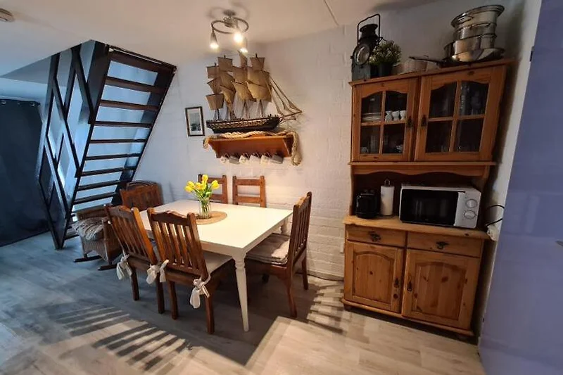 Wohnbereich mit Holzmöbeln, Couch, Esstisch und dekorativen Details.