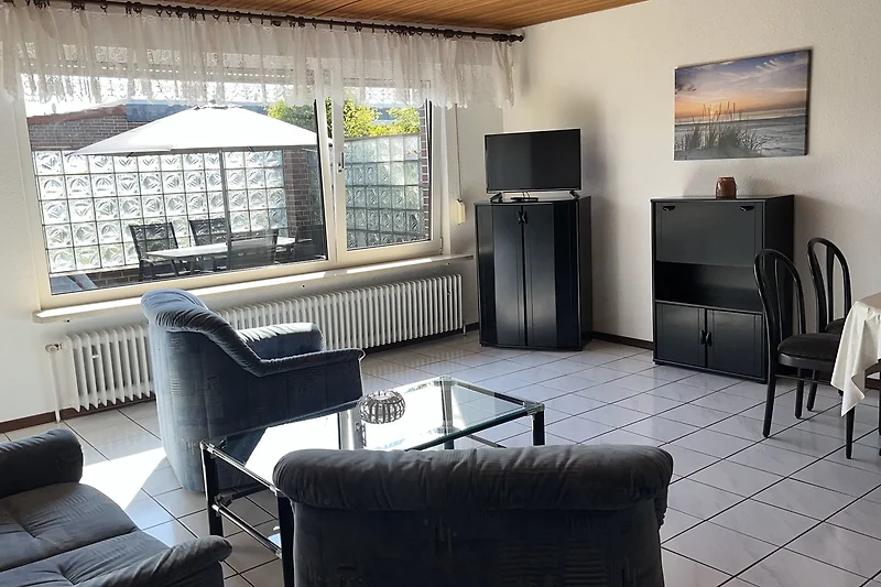 Großzügiger Loftbereich mit Tagesbett, Pflanzen und großem Fenster.