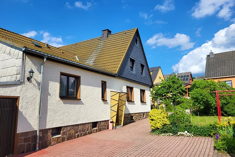 Historisches Landhaus mit markanter Fassade, Hof und gepflegtem Weg.