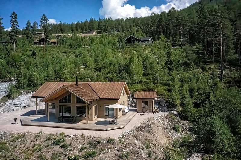 Blockhaus im Bergdorf, umgeben von Lärchen und Kiefern.
