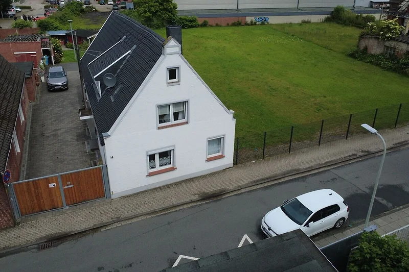 Wohngebiet mit Häusern, Baumreihen und parkenden Autos