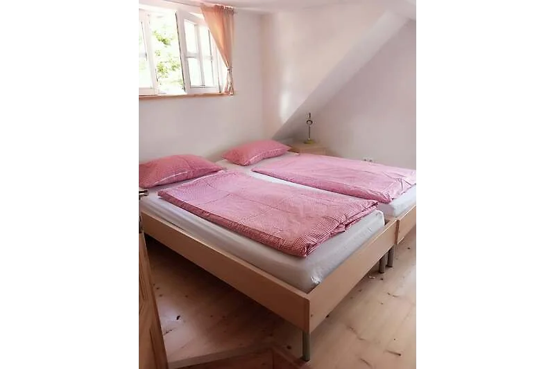Holzbett mit ruhigem Schlafzimmerambiente.