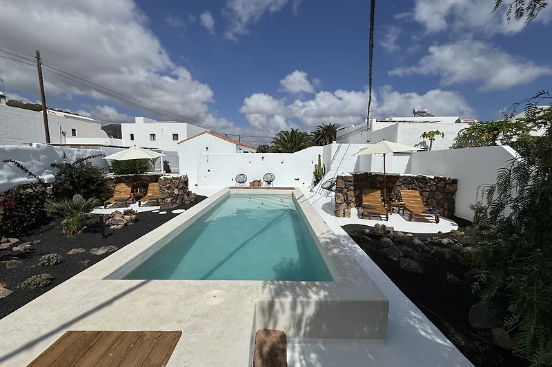 Palmen säumen den Pool und prägen die tropische Atmosphäre.