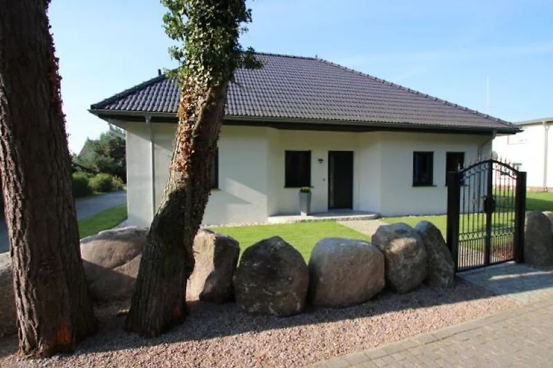 Wohnhaus mit Natursteinmauer und Zufahrt.