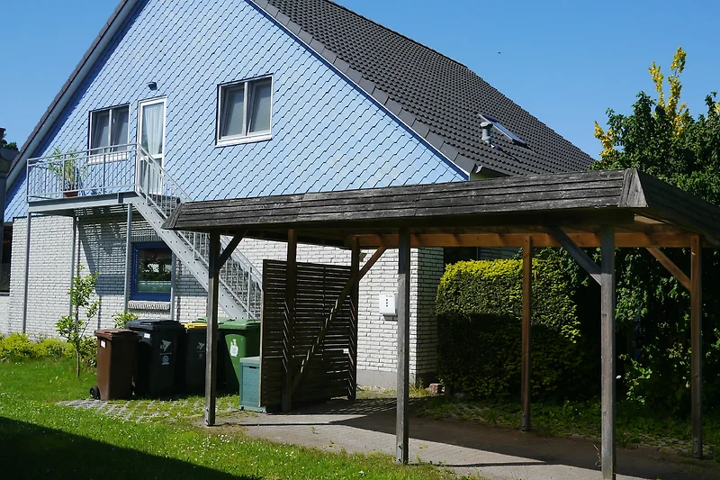Wohnhaus mit Eingang zur Ferienwohnung, mit Außentreppe und Carport