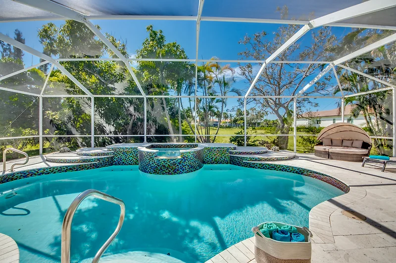 Pool im Grün eines Ferienresorts mit Villa und Garten