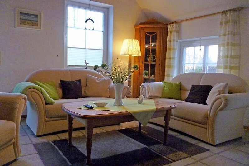 Gemütliches Wohnzimmer mit Holzmöbeln, Sofa und Fenster.