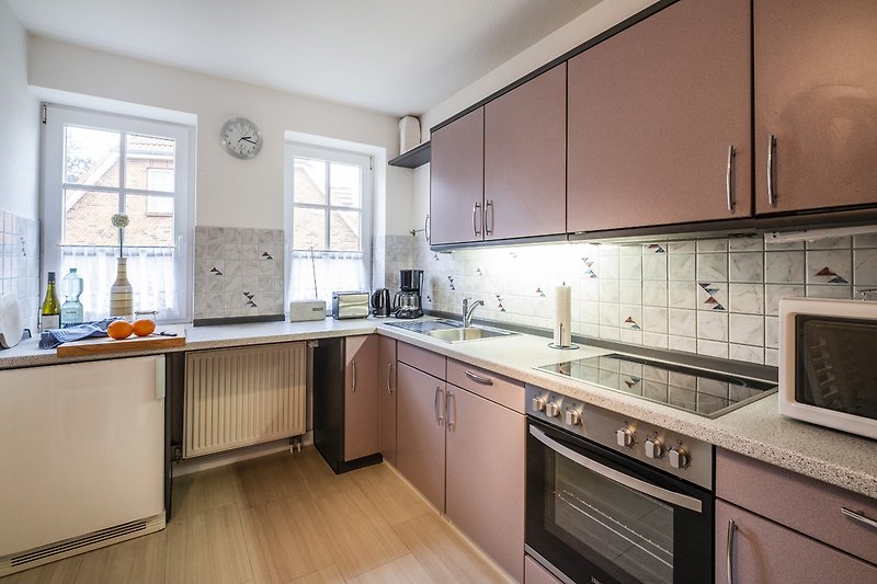 Moderne Küche mit eleganten Schränken, Granitarbeitsplatte und Fenster.