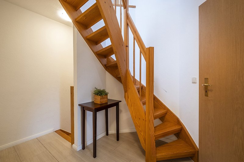Elegante Treppe mit Holzgeländer und stilvoller Beleuchtung.